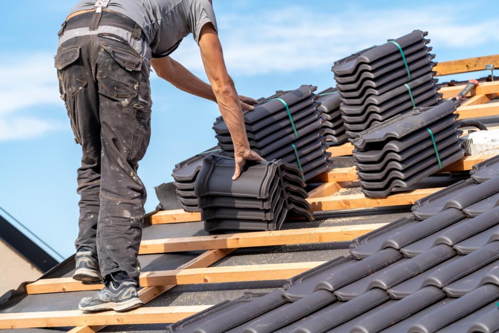 Roofers installing new underlayment on house roof in Miami