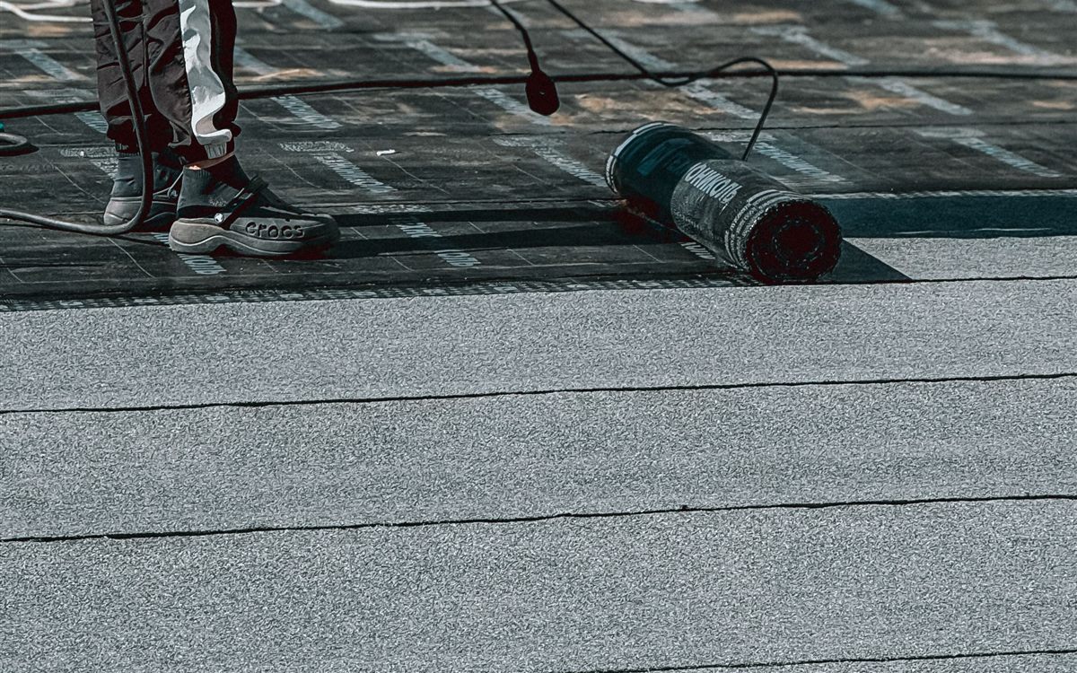 Coated flat roof surface showing sealed membrane seams and field